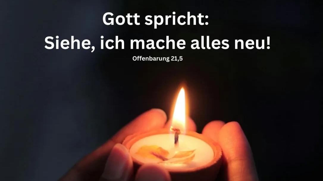 Das Plakat zeigt neben den Informationen zwei Hände, die im Dunkeln ein brennendes Teelicht zeigen.